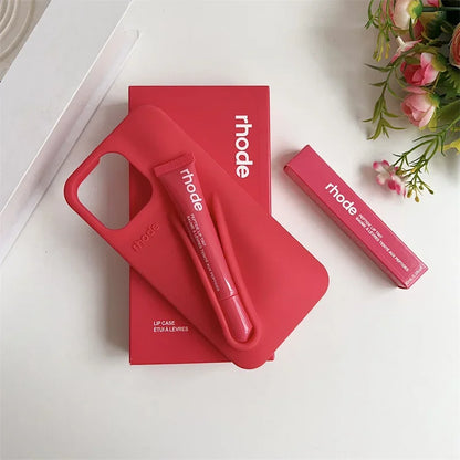 Red 'rhode' lip care products on a white surface with flowers in the corner.