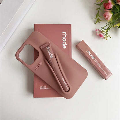 Pink phone case and lip balm set with 'rhode' branding on a white surface.