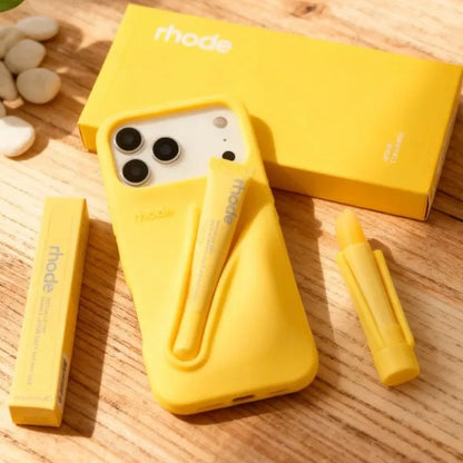 Yellow Rhode phone case with Rhode branding on a wooden surface