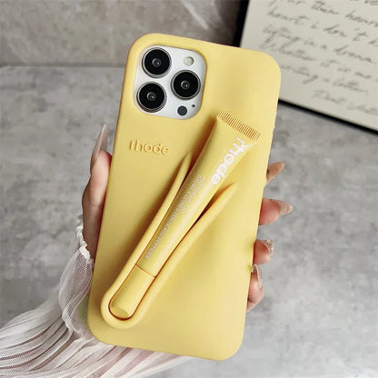 Yellow phone case with a pen holder held by a hand on a neutral background