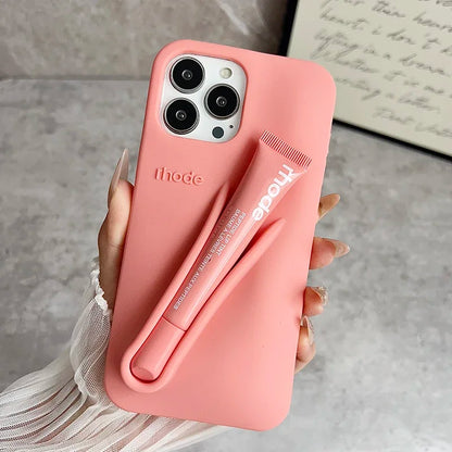 Pink phone Rhode case with a pen holder attached, held by a hand on a neutral background.