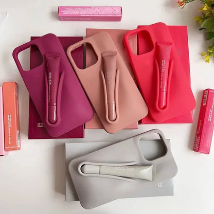 Three phone cases in pink, red, and gray on a white surface with a plant in the corner.
