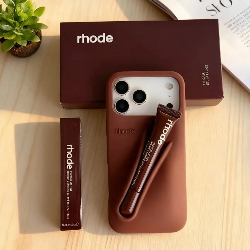 Brown phone case with pen holder and 'rhode' branding on a wooden surface.