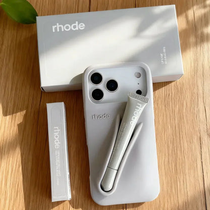 White Rhode phone case with 'rhode' branding on a wooden surface