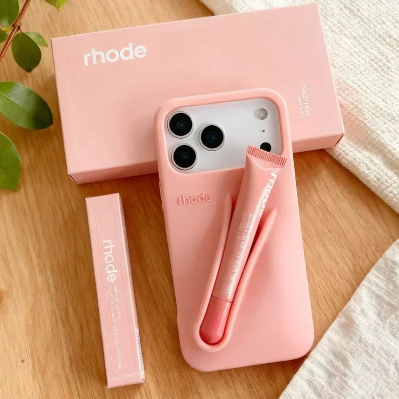 Pink Rhode phone case with pen holder and 'rhode' branding on a wooden surface.