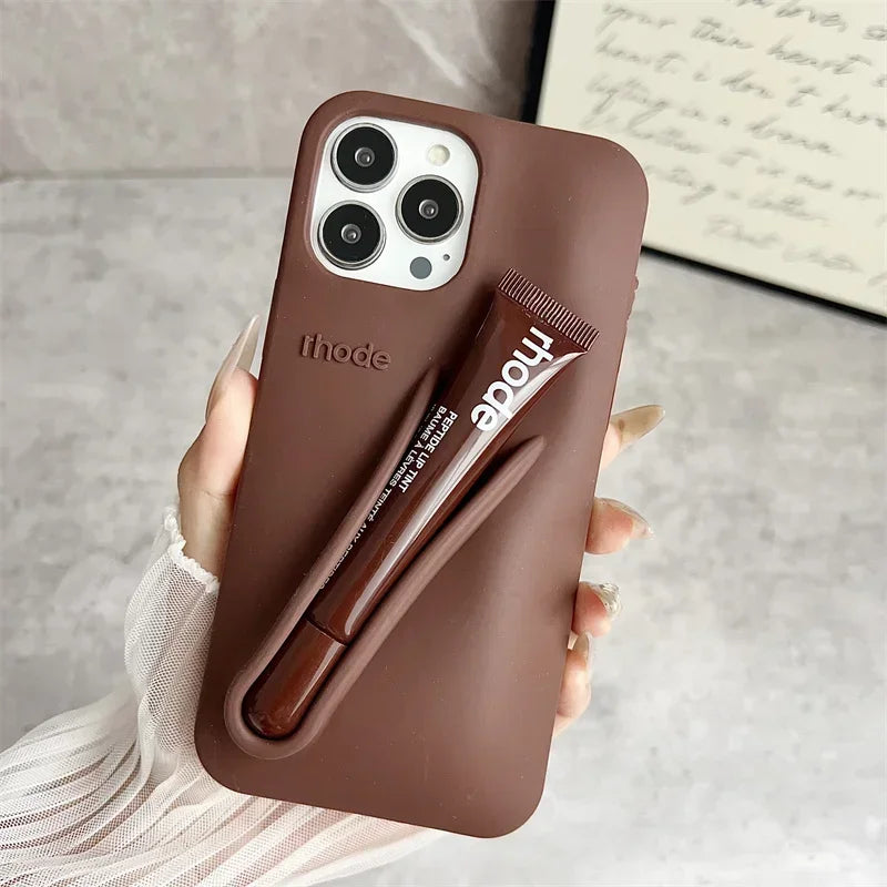Brown phone case with a pen holder holding a pen, on a neutral background