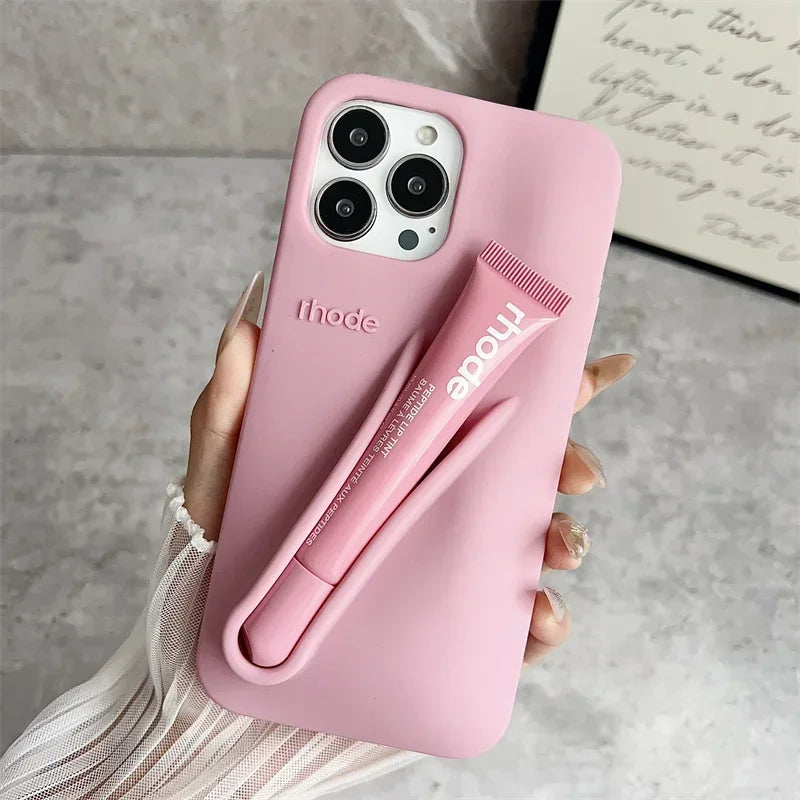 Pink phone case with a pen holder attached, held by a hand on a neutral background.