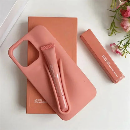 Pink Rhode lip case with lip balm and lip gloss on a white surface with flowers.