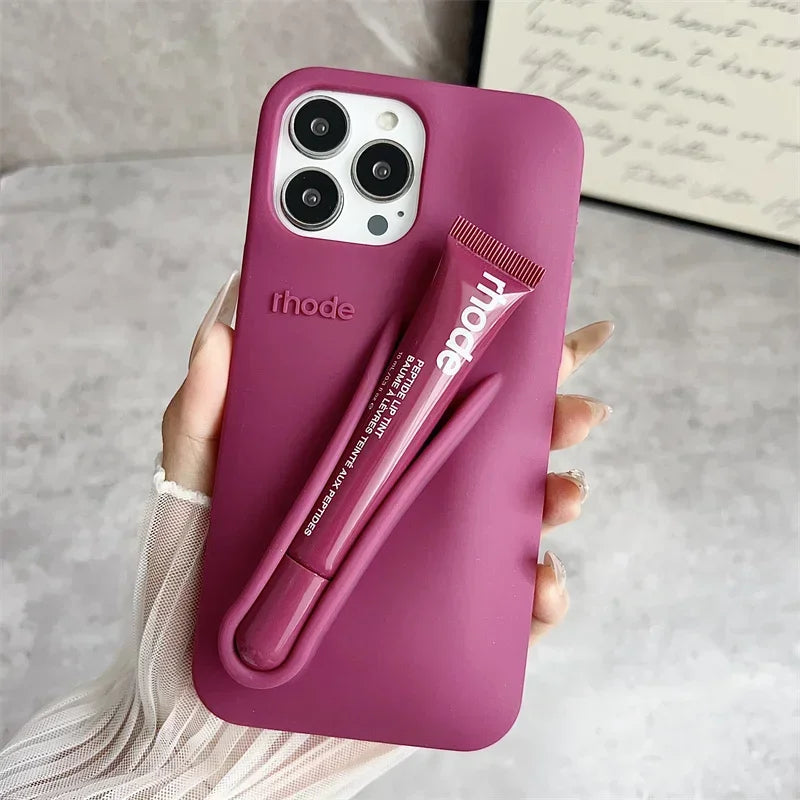 Pink Rhode phone case with a pen holder attached, held by a hand on a neutral background
