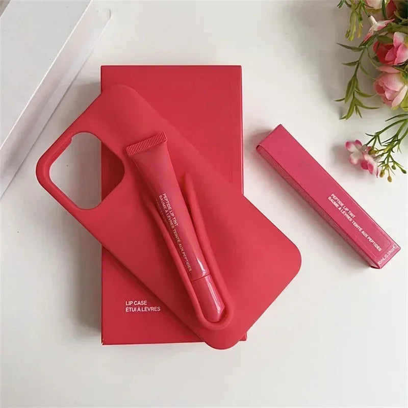 Red Rhode lip case and lip balm on a white surface with flowers in the background