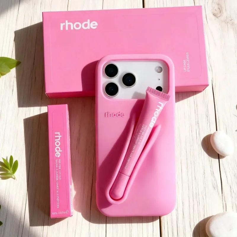 Pink phone case with 'rhode' branding on a wooden surface