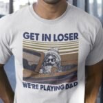 "Get In Loser We're Playing D&D" expresses a fun and nerdy vibe. This shirt is a playful invitation for fellow Dungeons & Dragons enthusiasts to join in the adventure and embrace the tabletop gaming spirit.